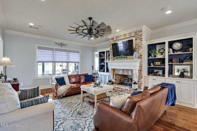 living room featuring crown molding, a brick fireplace, dark hardwood / wood-style floors, and ceiling fan