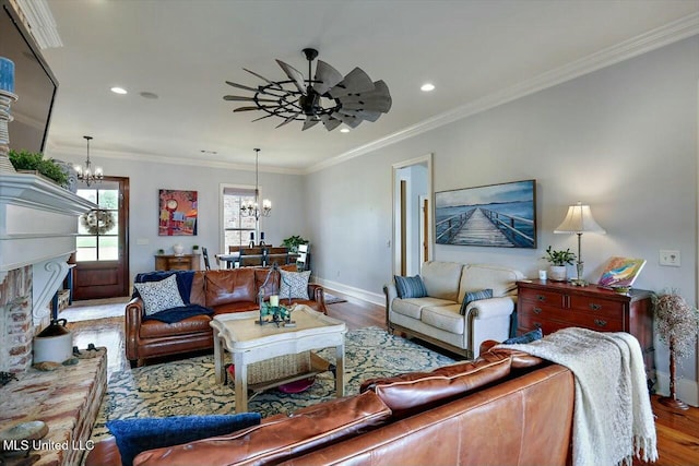 living room featuring ornamental molding, wood-type flooring, and ceiling fan with notable chandelier