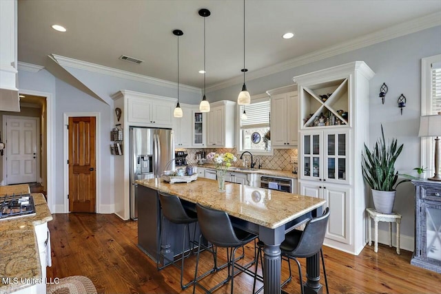 kitchen with white cabinetry, light stone counters, and a kitchen island