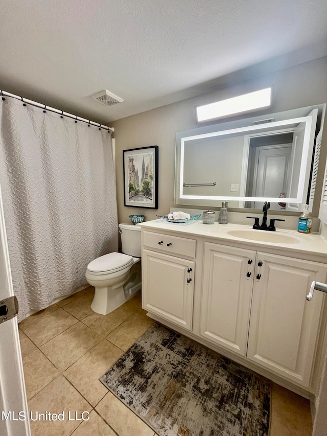 bathroom featuring vanity, toilet, a textured ceiling, and tile patterned flooring