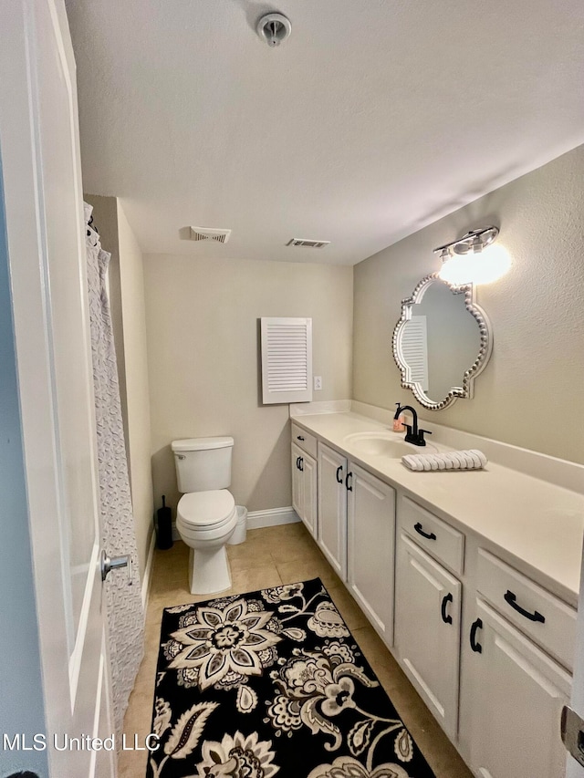 bathroom with vanity, toilet, and tile patterned flooring