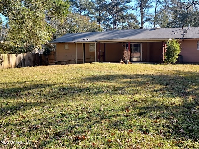 rear view of property with a lawn