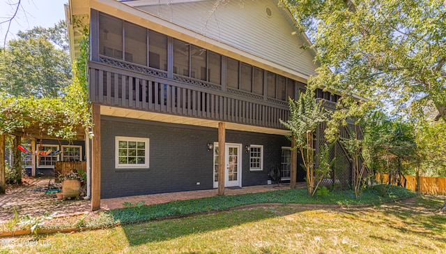 rear view of property with french doors, a patio area, and a lawn