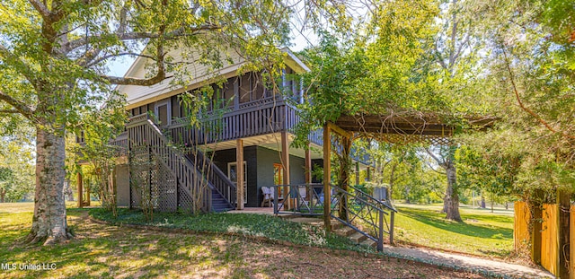 back of property with a yard and a sunroom