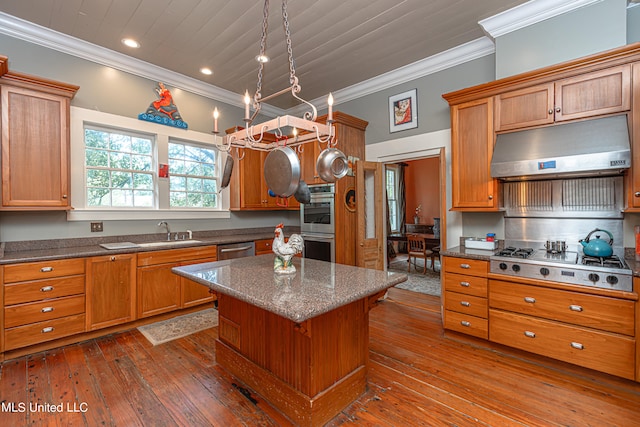 kitchen with dark hardwood / wood-style floors, stainless steel appliances, sink, crown molding, and a center island