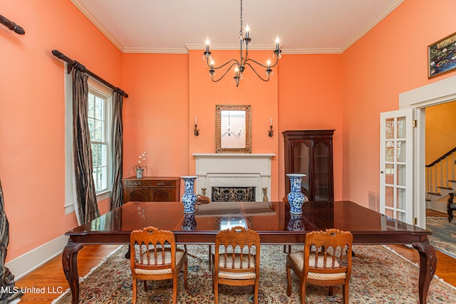 3775 Coker Rd, Madison, MS 39110 - dining area featuring wood finished floors, a chandelier, crown molding, baseboards, and a fireplace