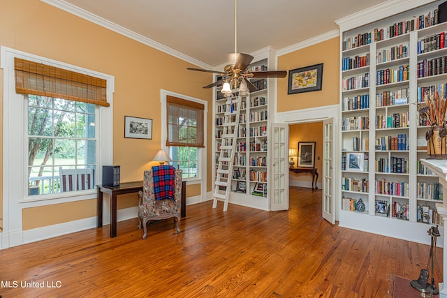 living area featuring crown molding, wood-type flooring, and ceiling fan