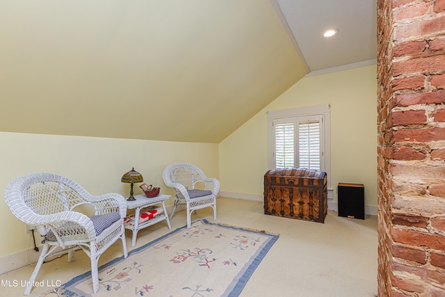 sitting room featuring vaulted ceiling and carpet flooring