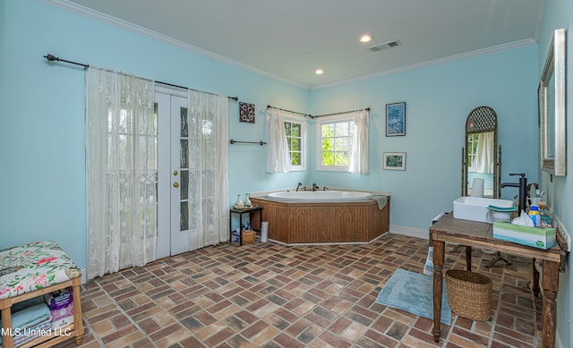 bathroom featuring ornamental molding, sink, french doors, and a bathing tub