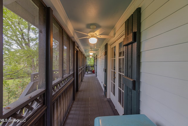 unfurnished sunroom with ceiling fan