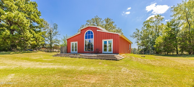 view of outdoor structure featuring french doors and a lawn