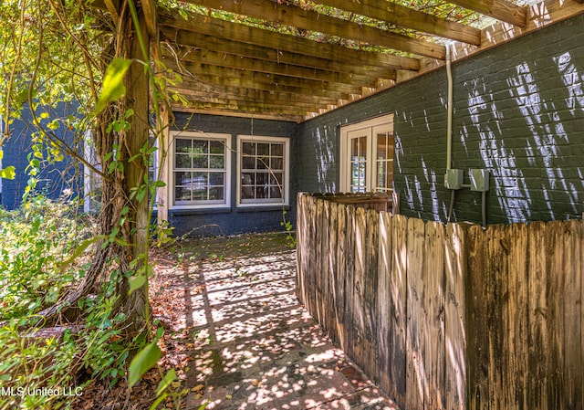 view of side of home featuring a patio area, french doors, and a pergola