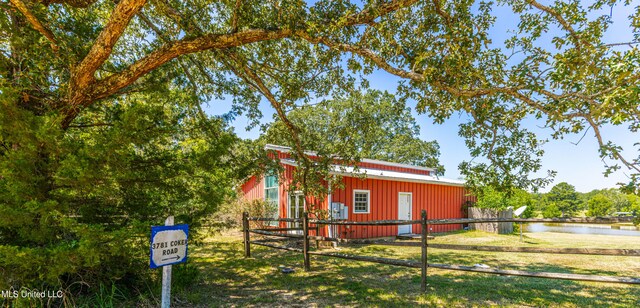 view of property exterior with a yard and a water view