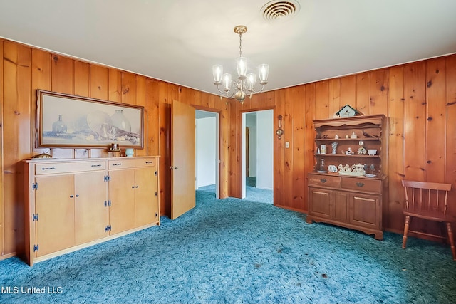 interior space featuring an inviting chandelier and wood walls