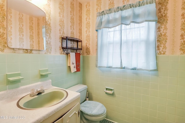 bathroom with tile walls, vanity, and toilet