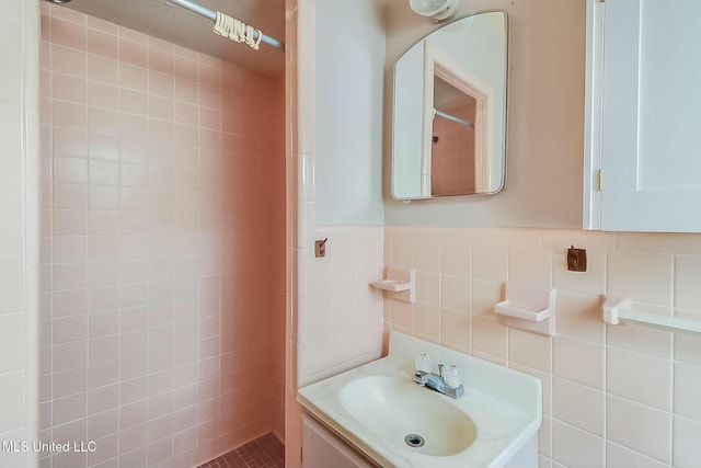 bathroom featuring vanity, tile walls, and walk in shower