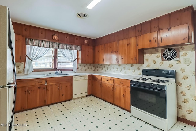 kitchen featuring white dishwasher, fridge, gas range, and sink