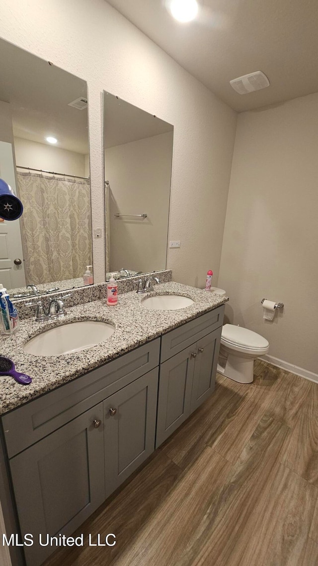 bathroom featuring vanity, walk in shower, toilet, and wood-type flooring