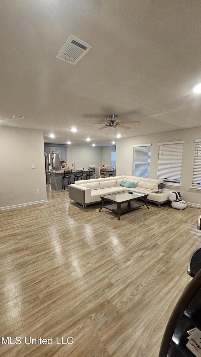 living area featuring visible vents, ceiling fan, light wood-style floors, and recessed lighting