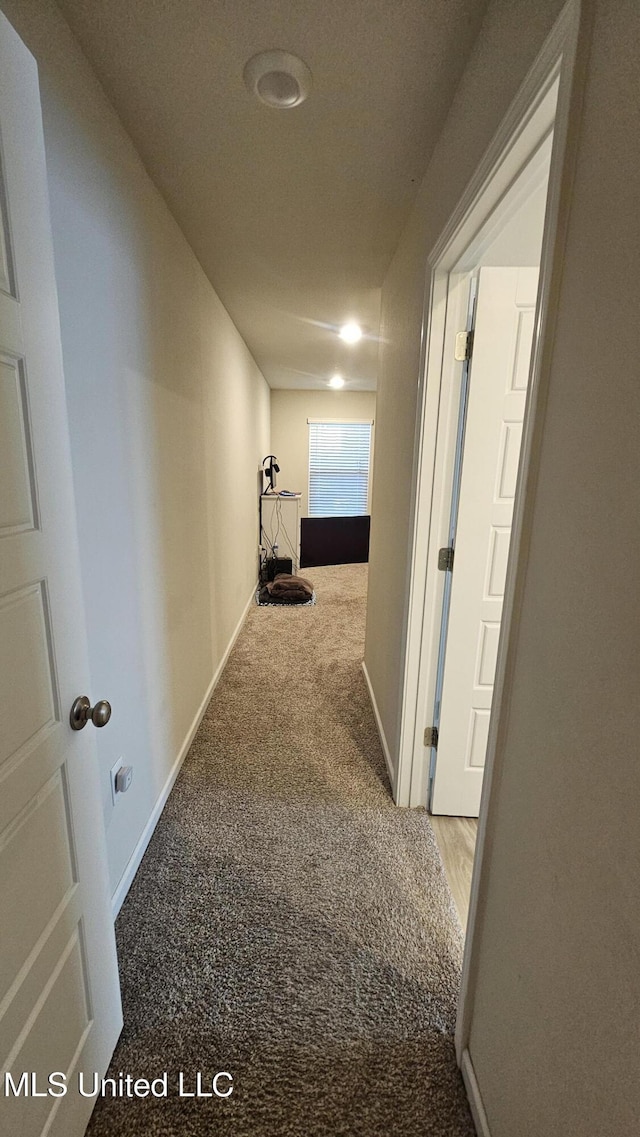 corridor with carpet flooring and baseboards