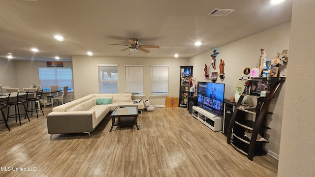 living room with light wood-type flooring and ceiling fan