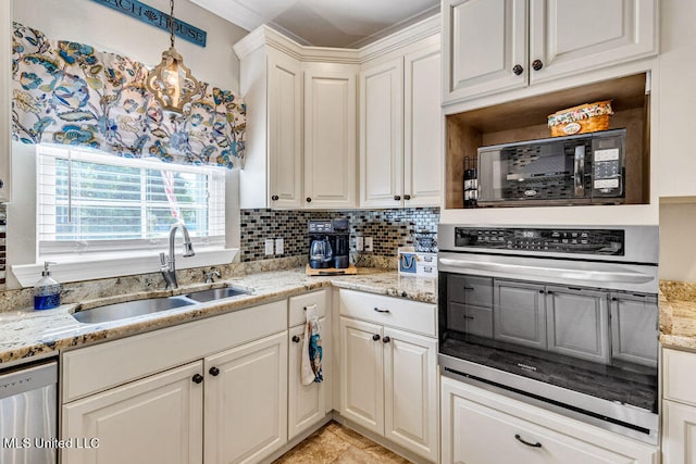 kitchen featuring appliances with stainless steel finishes, sink, hanging light fixtures, light stone counters, and decorative backsplash