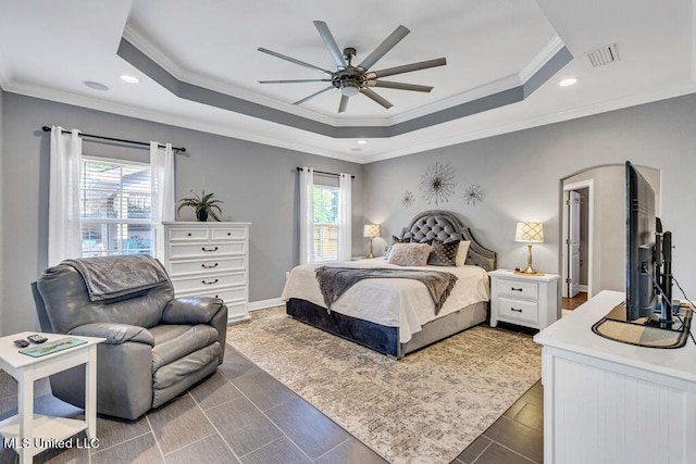 bedroom featuring crown molding, a tray ceiling, and ceiling fan