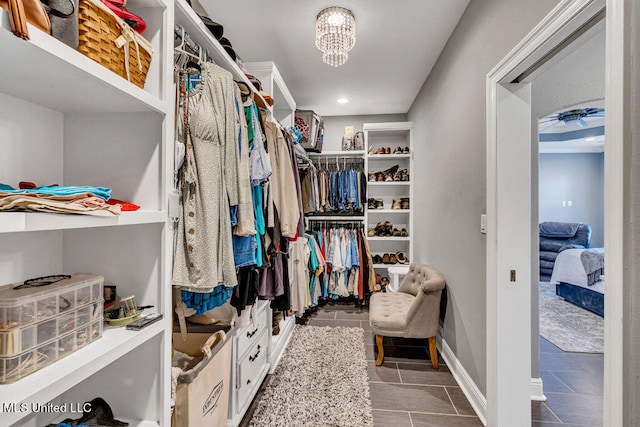 spacious closet with an inviting chandelier