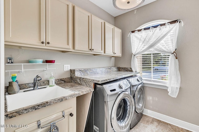 washroom featuring cabinets, sink, and washing machine and dryer