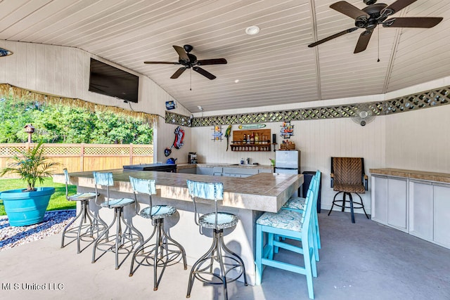 view of patio with exterior kitchen, exterior bar, and ceiling fan