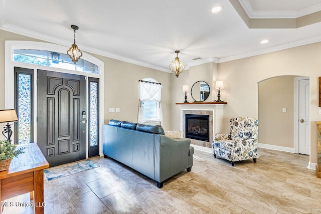 entryway featuring crown molding, plenty of natural light, and a fireplace