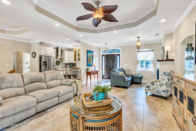 tiled living room featuring crown molding and a raised ceiling