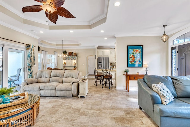 living room featuring crown molding, ceiling fan, a healthy amount of sunlight, and a raised ceiling