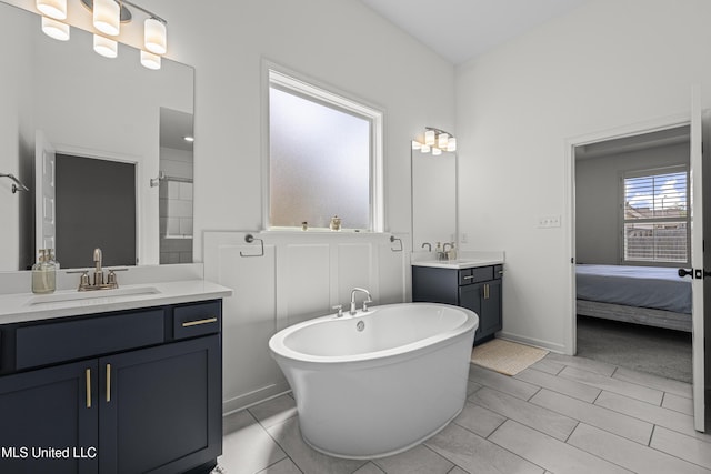 full bath featuring a soaking tub, two vanities, a sink, and ensuite bath