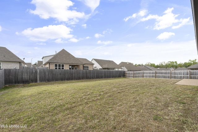 view of yard featuring a fenced backyard and a residential view