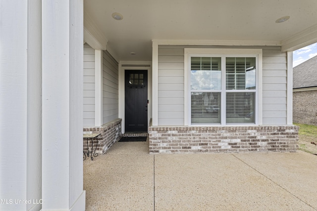 doorway to property featuring brick siding