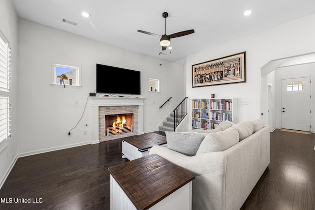 living area with visible vents, a warm lit fireplace, a ceiling fan, dark wood-style floors, and recessed lighting