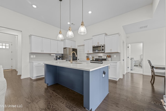 kitchen with visible vents, a sink, dark wood finished floors, stainless steel appliances, and decorative backsplash