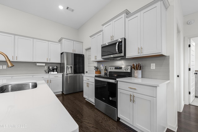 kitchen with light countertops, appliances with stainless steel finishes, a sink, and visible vents