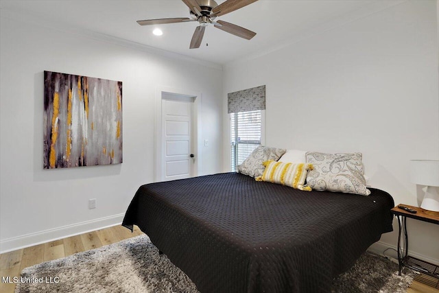 bedroom with ornamental molding, ceiling fan, and wood-type flooring