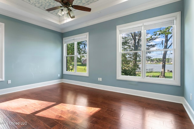 spare room featuring ornamental molding, wood-type flooring, and a healthy amount of sunlight