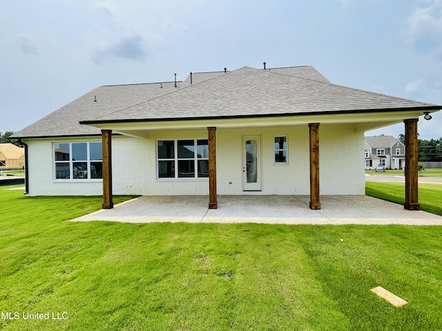 back of property featuring a patio area and a yard