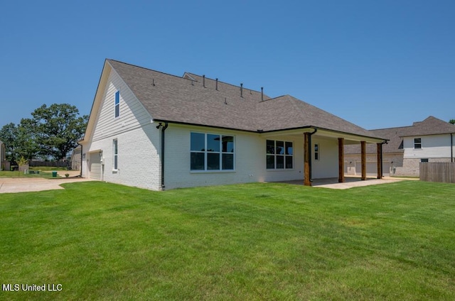 back of property featuring a patio, a lawn, and a garage