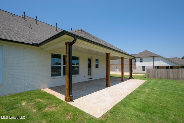 rear view of house with a patio area and a lawn