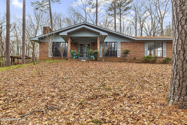 single story home featuring a chimney and brick siding