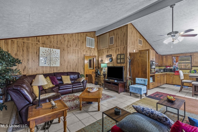 living room featuring lofted ceiling, a textured ceiling, light tile patterned flooring, and visible vents