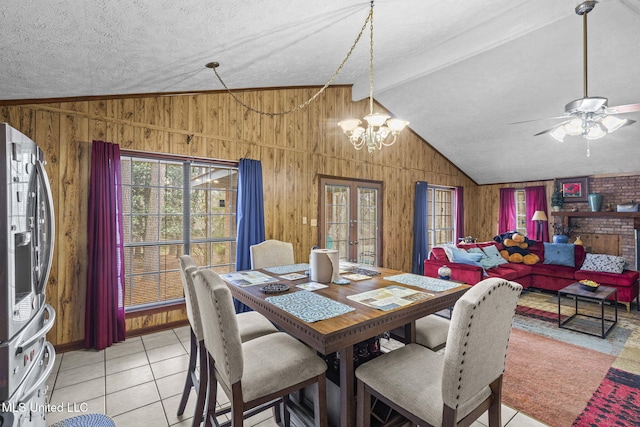 dining room with french doors, a notable chandelier, vaulted ceiling with beams, light tile patterned flooring, and wood walls