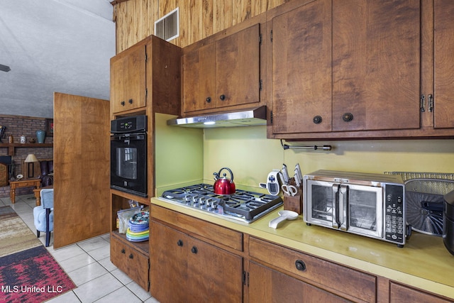 kitchen with light tile patterned flooring, under cabinet range hood, visible vents, light countertops, and appliances with stainless steel finishes