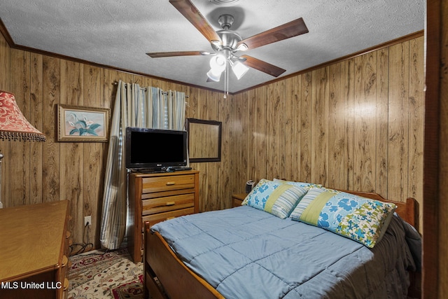 bedroom with a textured ceiling, wood walls, a ceiling fan, and crown molding