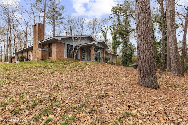 view of front of home with brick siding and a chimney